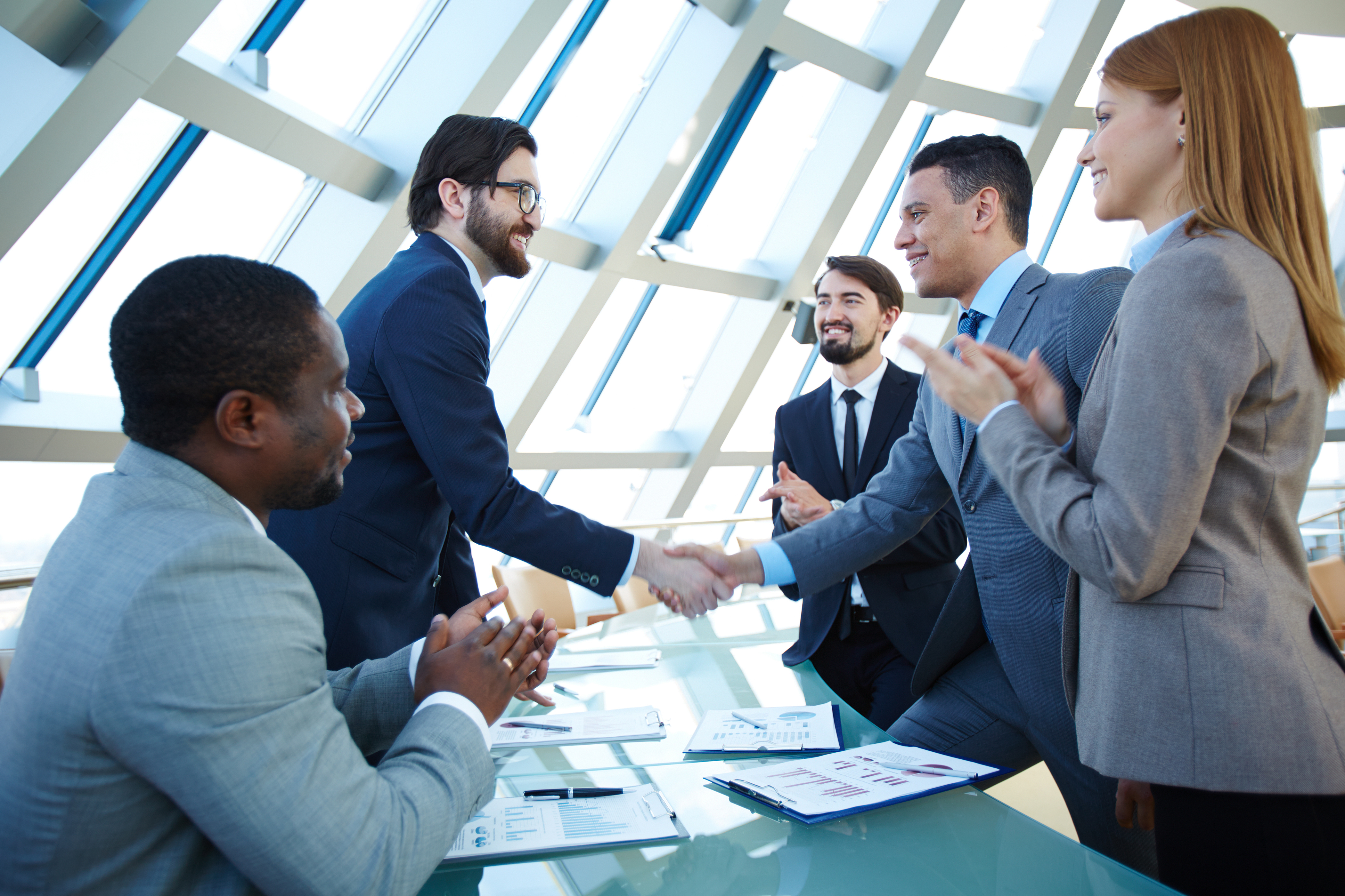 Group of business people congratulating their colleagues with striking grand deal